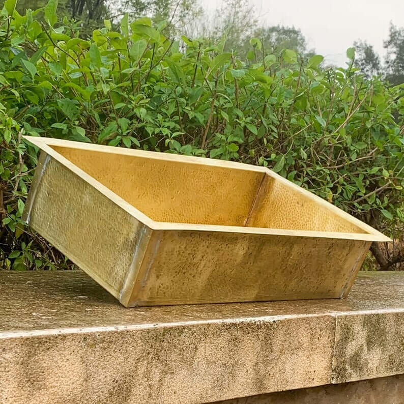 Handmade golden brass sink for bathroom decor, showcasing unique artisan craftsmanship and natural finishes.