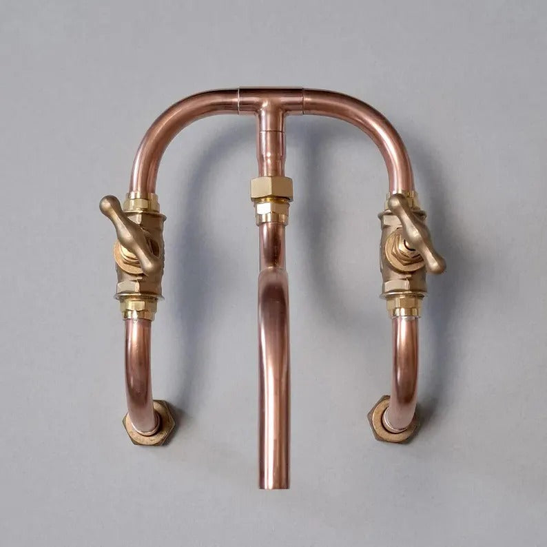 Handmade copper wall mount faucet with solid brass valves, showcasing industrial design for kitchen or bathroom.