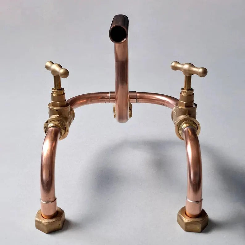 Handmade copper wall mount faucet with solid brass valves, showcasing an industrial artisan design for kitchen or bathroom.