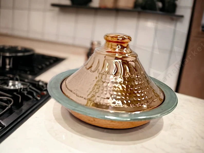 Luxurious handcrafted Moroccan copper tagine on a kitchen counter, showcasing a stylish lid and serving tray.