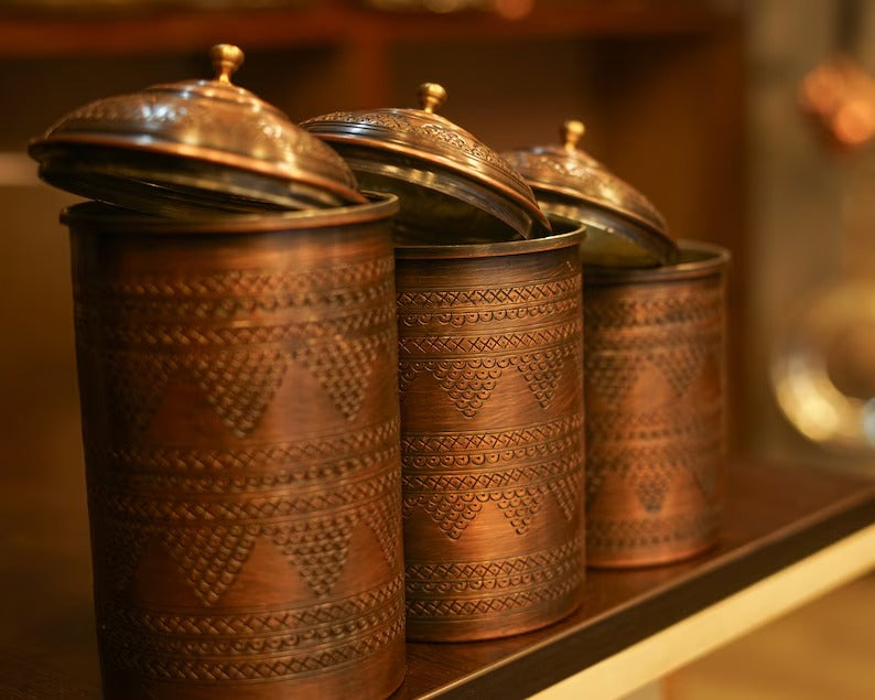 Set of 3 handmade copper spice containers with intricate designs and decorative lids, perfect for kitchen decor.