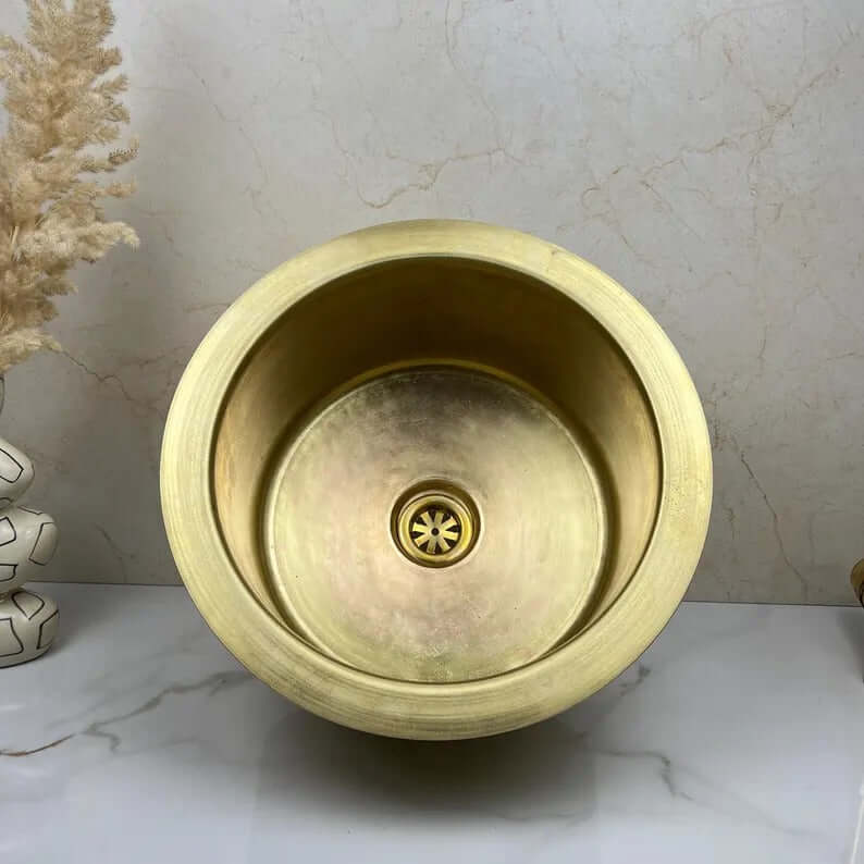 Handcrafted round brass sink, showcasing elegant design and premium quality, perfect for kitchen and bathroom use.