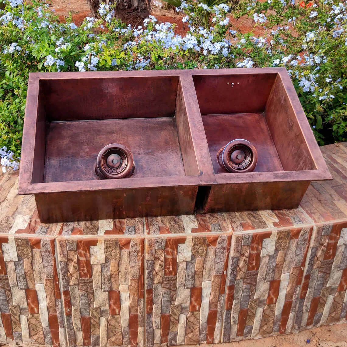 Handmade double copper sink with two basins, showcasing hammered texture and elegant design, ideal for a farmhouse kitchen.