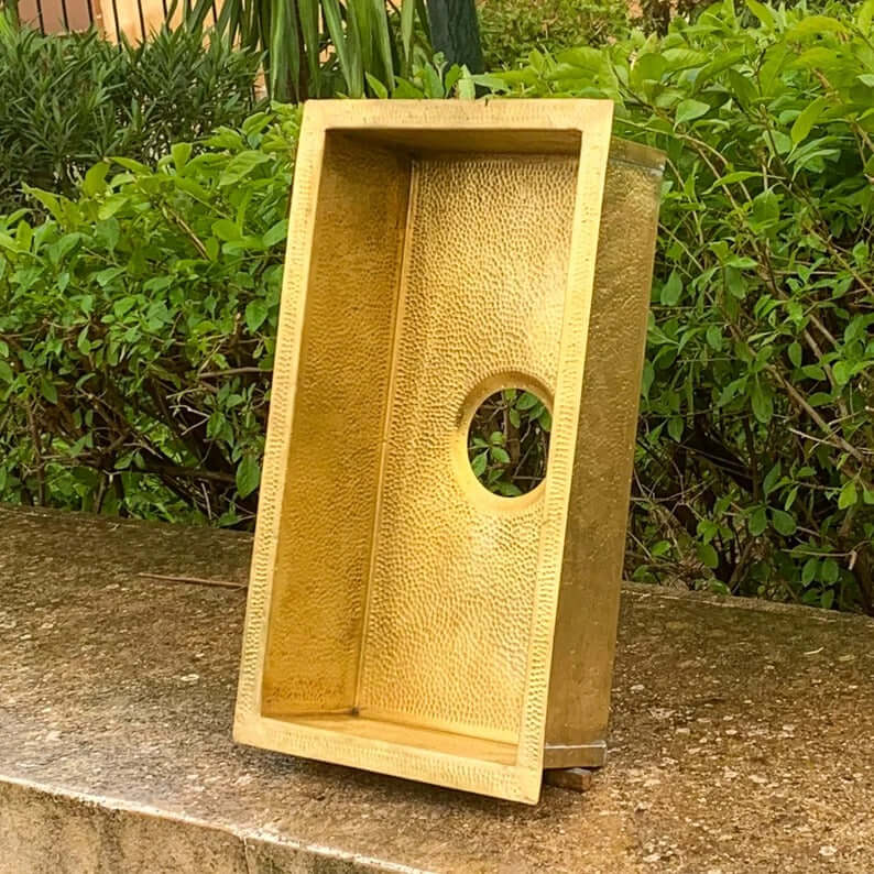 Handmade brass sink with textured finish and round hole, perfect for Moroccan-style bathrooms.