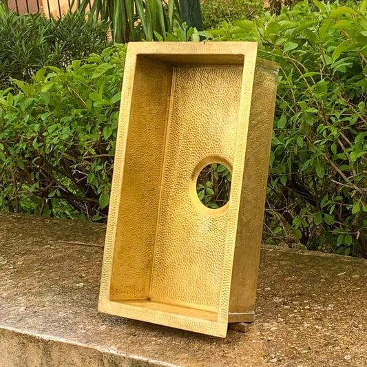 Handmade brass sink with textured finish and round hole, perfect for Moroccan-style bathrooms.