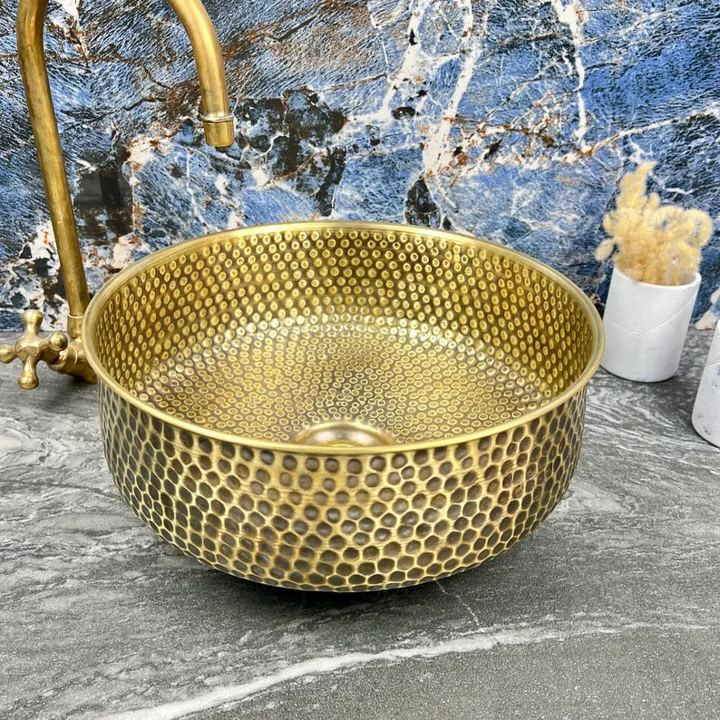 Hand-hammered brass round sink with drain, showcasing Moroccan craftsmanship and elegant design.
