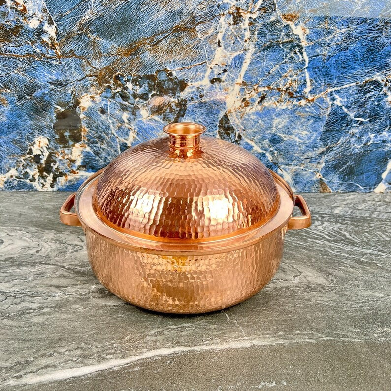 Handmade copper cooking pot with hammered finish on stone background, perfect for Moroccan kitchenware.