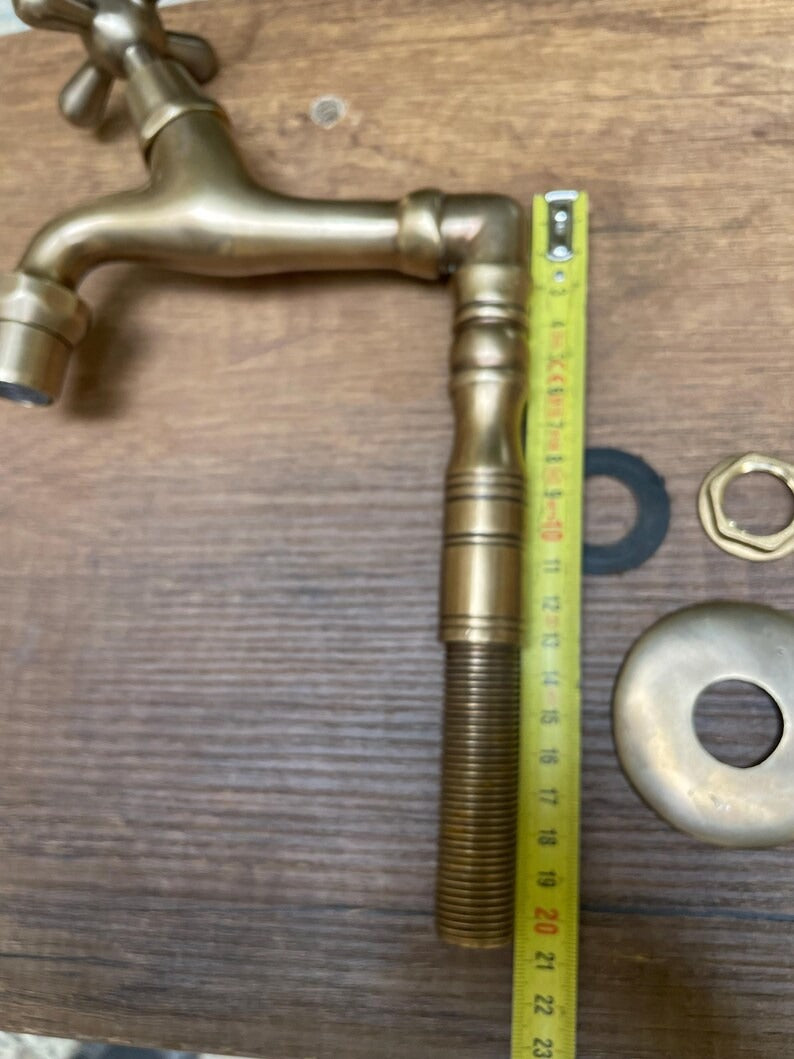 Brass water filter faucet with a measuring tape on a wooden surface, showcasing its durable construction and design.