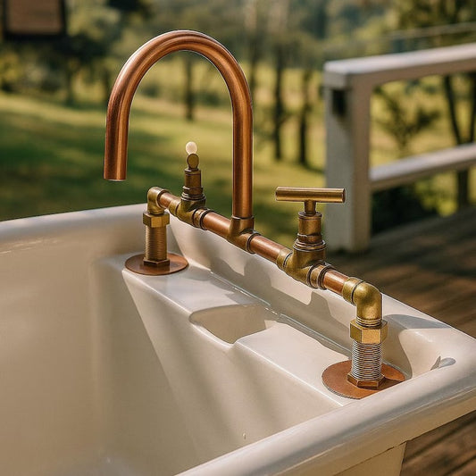 Handmade copper and brass faucet mixer tap installed on a vintage bathtub outdoors, showcasing rustic design.