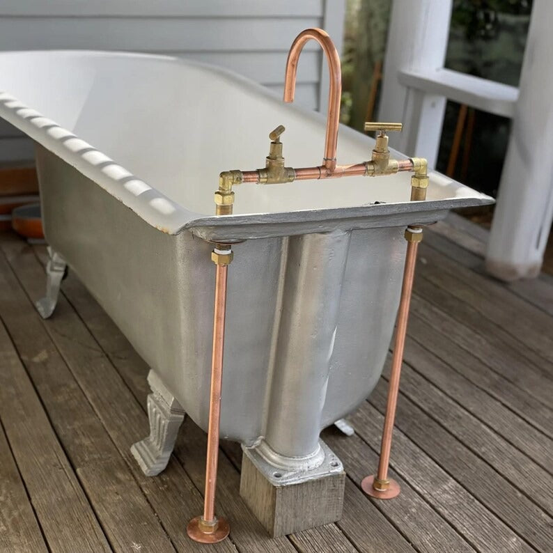 Handmade copper and brass faucet mounted on a vintage clawfoot bathtub, showcasing rustic farmhouse style.