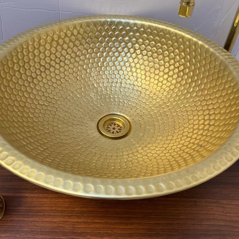 Handmade brass sink with a hammered finish, showcasing elegant texture perfect for bathroom or kitchen decor.