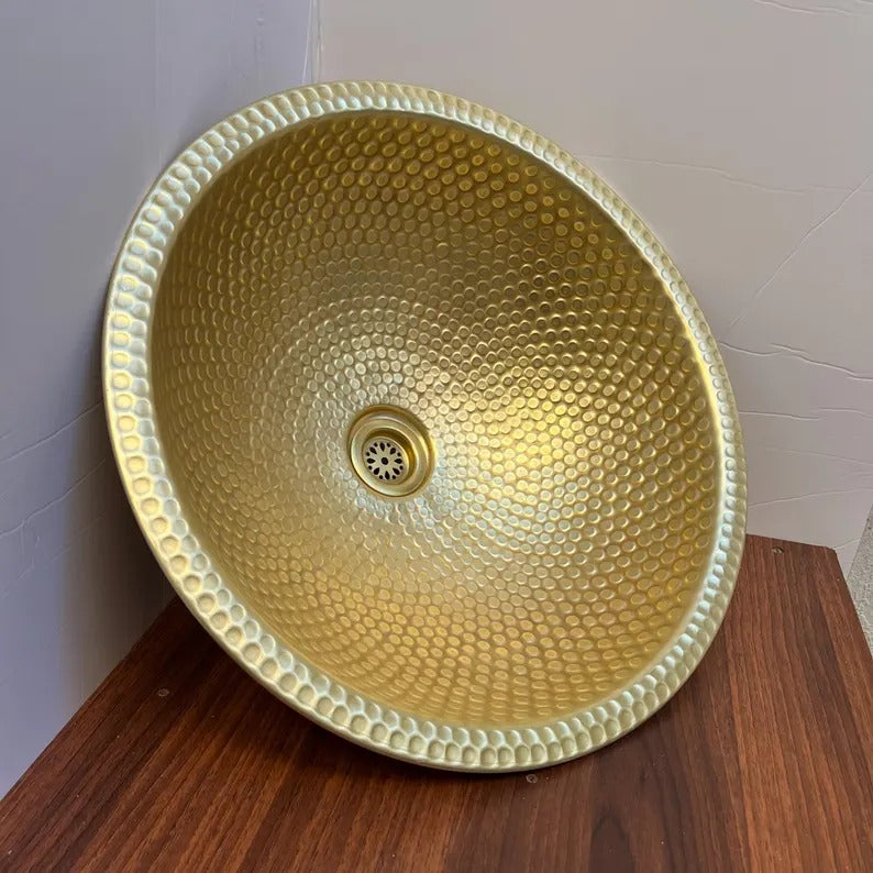 Handmade brass vessel sink with a polished hammered texture, perfect for bathroom decor.