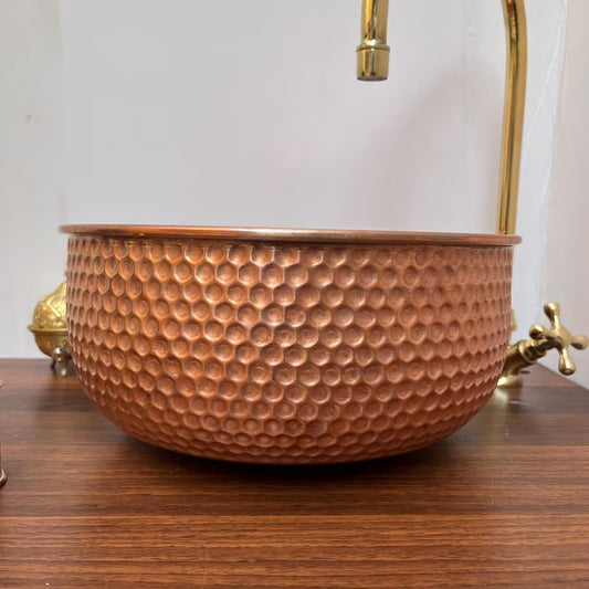 Handcrafted brushed copper bathroom sink showcasing a unique hammered design with elegant faucet.