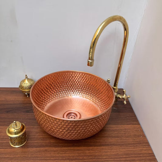 Brushed copper vessel sink with a modern design, featuring a honeycomb texture and a stylish gold faucet.