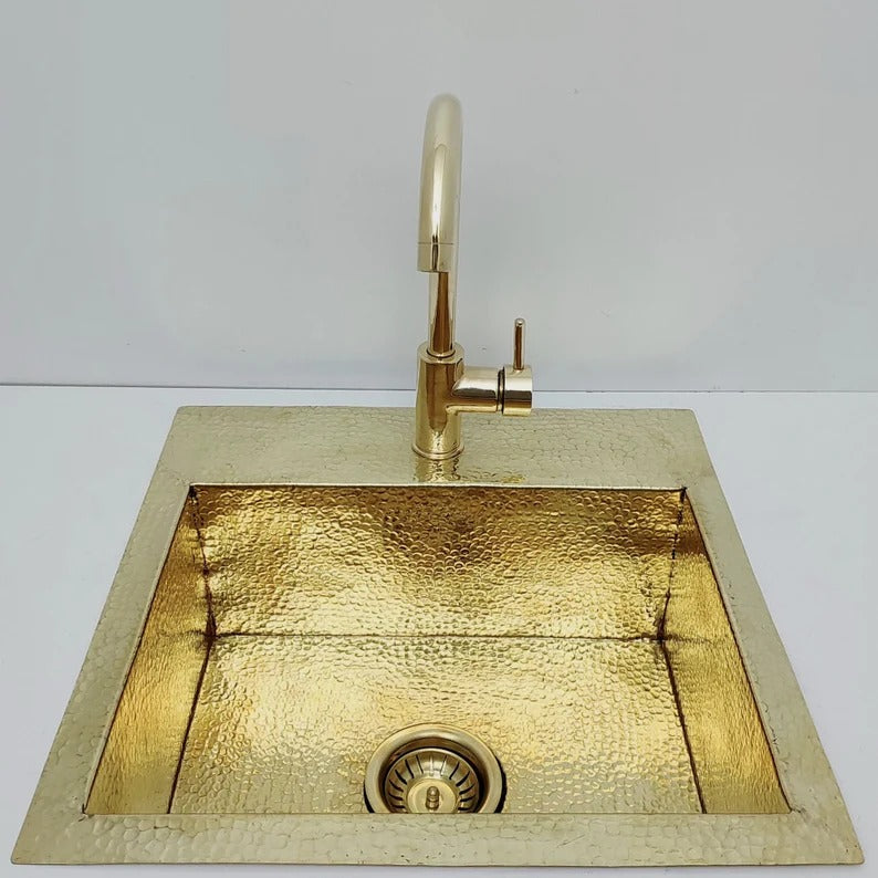 Unlacquered hammered solid brass sink with matching faucet, perfect for rustic or farmhouse kitchens and outdoor spaces.