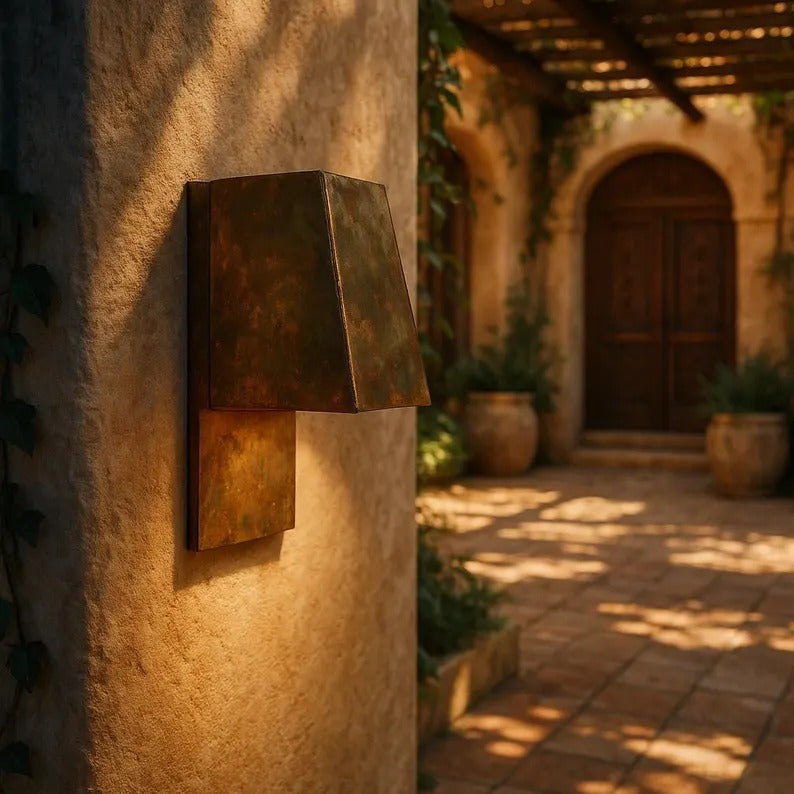 Handmade modern brass wall sconce illuminating a cozy entryway with warm light and geometric design.