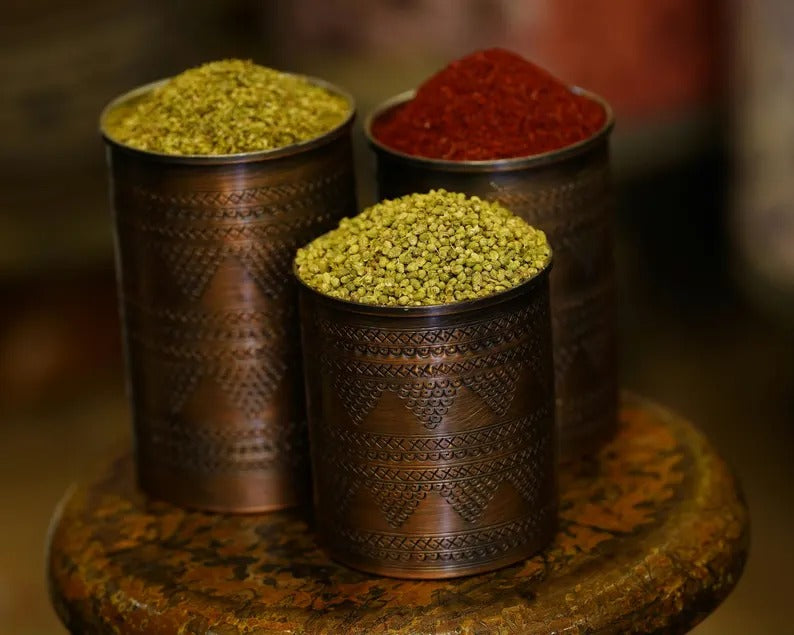 Set of 3 handmade copper spice containers filled with herbs and spices, showcasing intricate patterns.